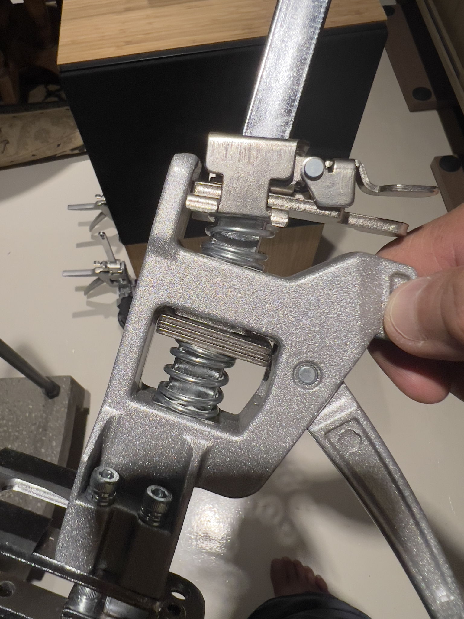 Side view of consumer grade lifting arm hand jack - the jacking lever lifts the arms about 7mm for each pull, while the two tabs above lower the arm at different speeds, for a 120kg maximum load each hand jack