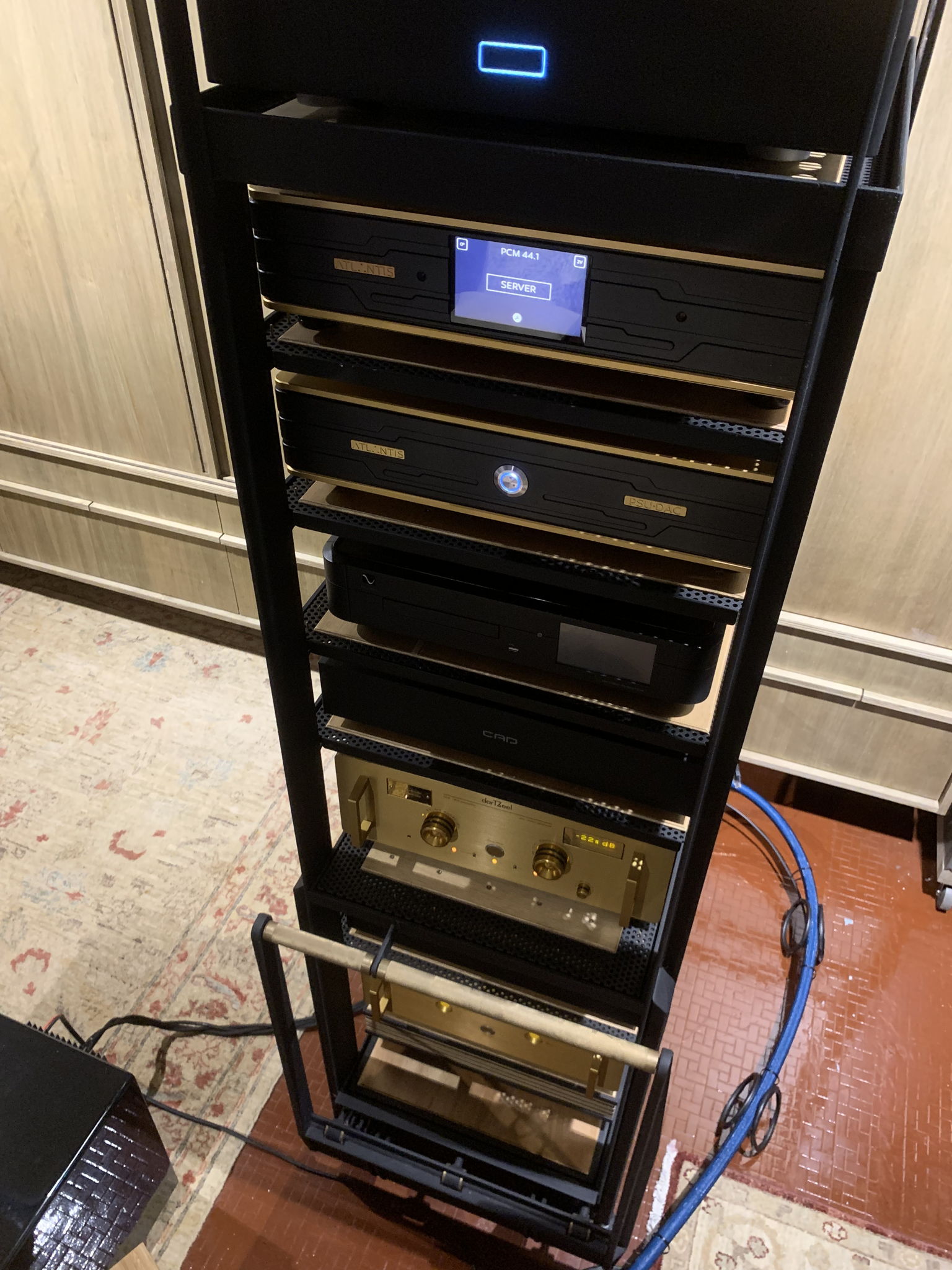 The vertical stack beginning with the server at the top, with equipment arranged from top to bottom in the direction of the signal path. The server delivers better sound quality further away from the floor and ground plane, in being used at the crown of the rack as a mass damper for the tall vertical stack.