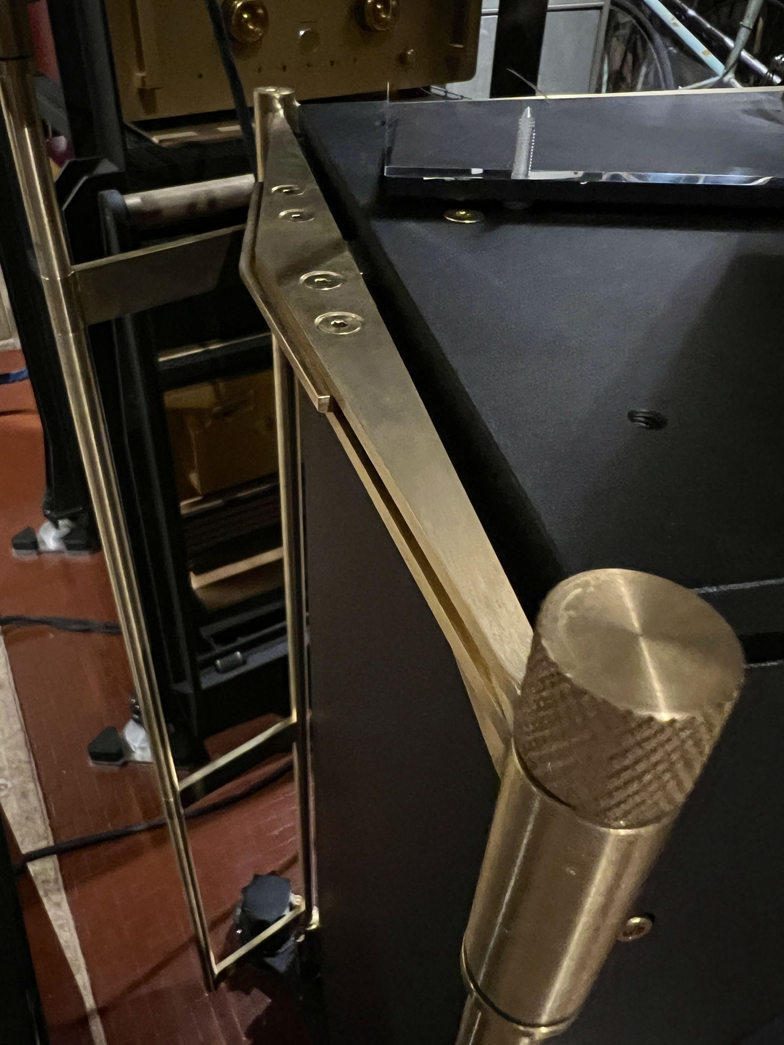 Knurled brass locking bolt head of the elac tweeter support frame. The frame is braced on either side of the main speaker by way of a brass tongue sandwiched between the upper and lower side frame plates, and against the recessed brass fastening screws of the main speaker top plate.