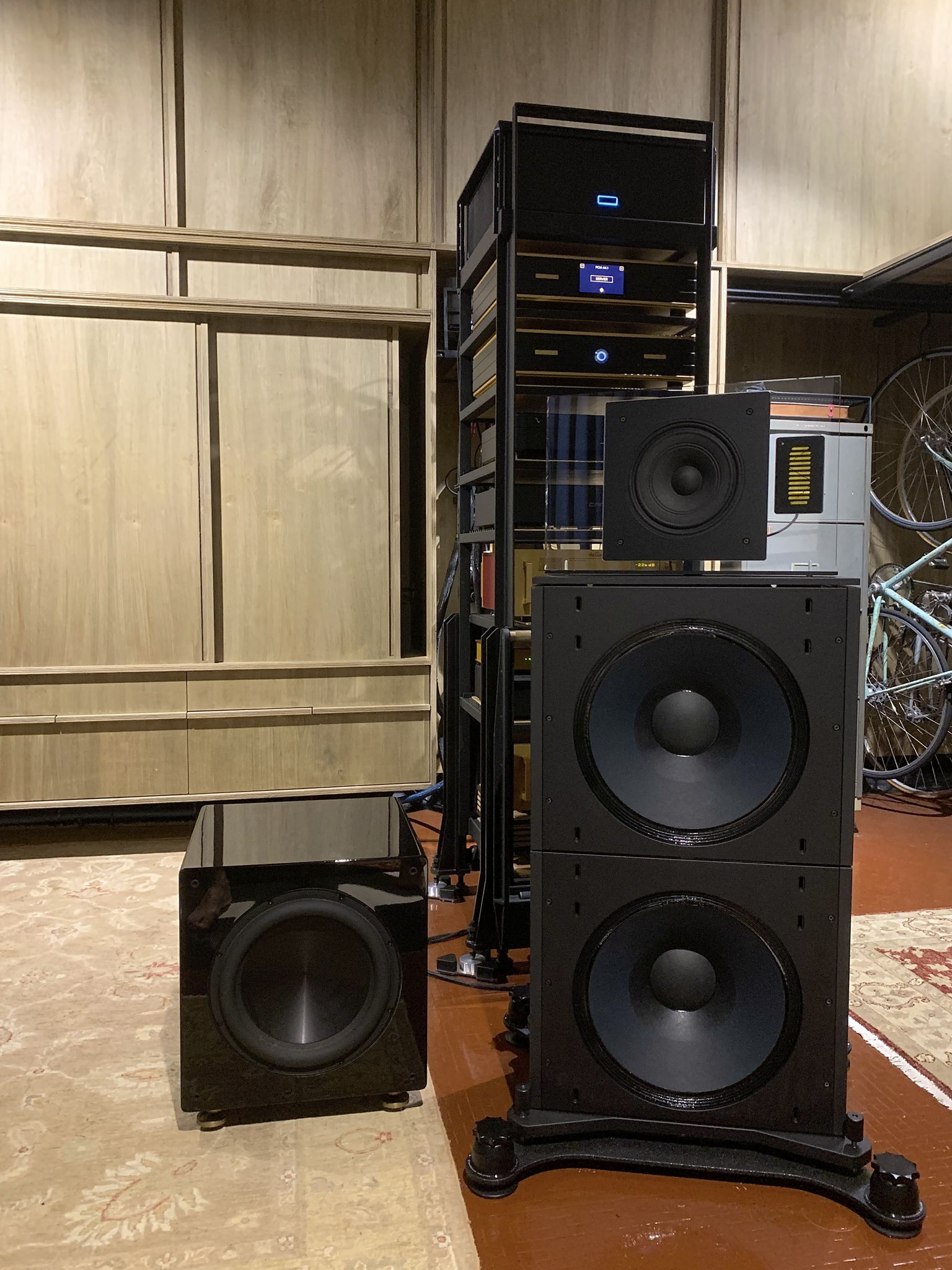 Front view of right speaker with one of the irregularly placed rythmik subwoofers alongside.