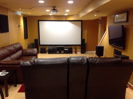 Dual purpose L-shaped movie room and videogame room. The TV is a separately powered 5.1 game system with back surrounds as ceiling speakers