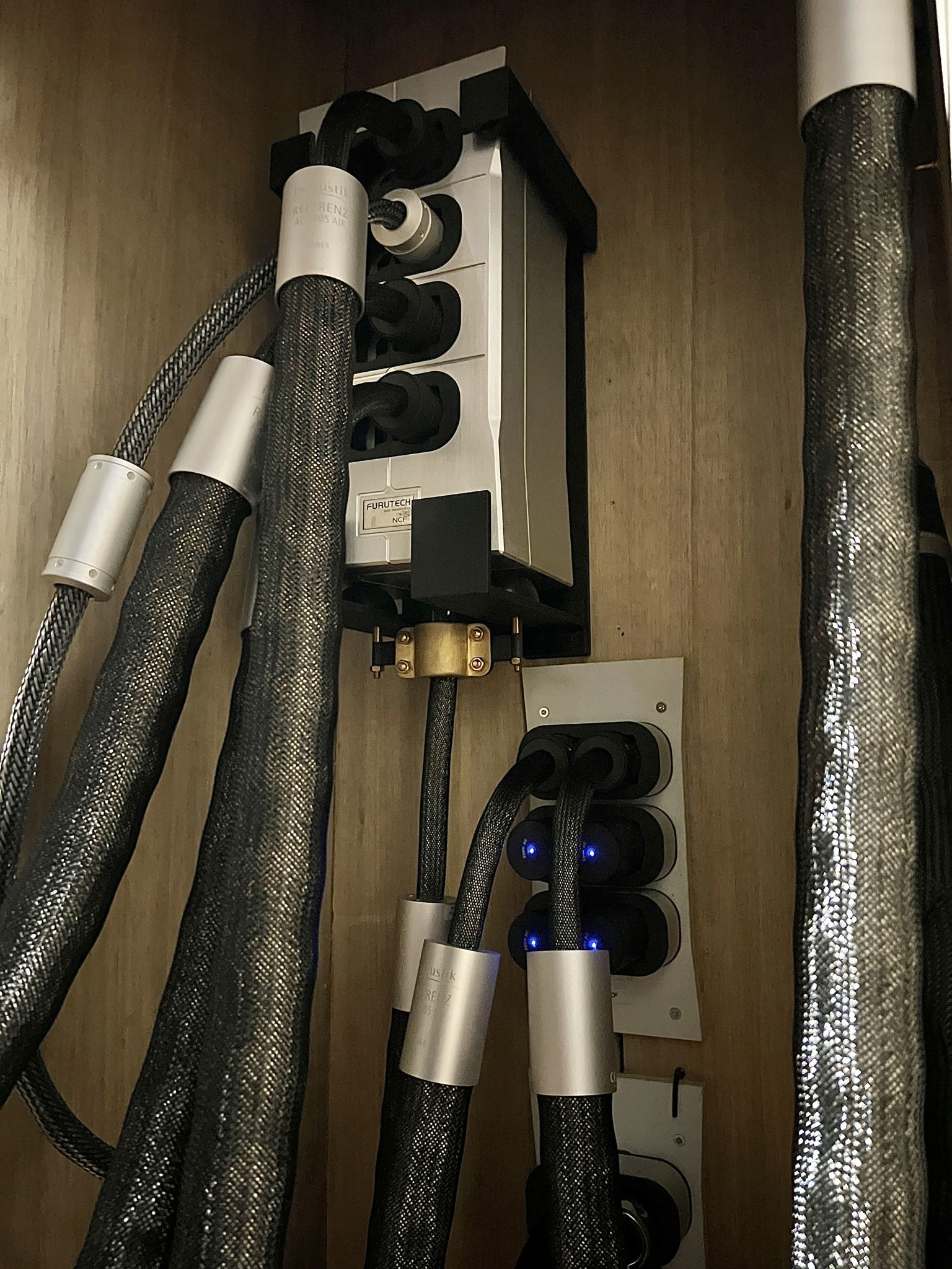 Current power distribution set up, with the Furutech power vault at its heart. A custom holster has been designed to hold it vertically with incoming cable pointed up and held in place with a brass clamp. The vault sits on two large isonode hemispheres, with four more smaller isonode hemispheres providing lateral isolation from the holster.  